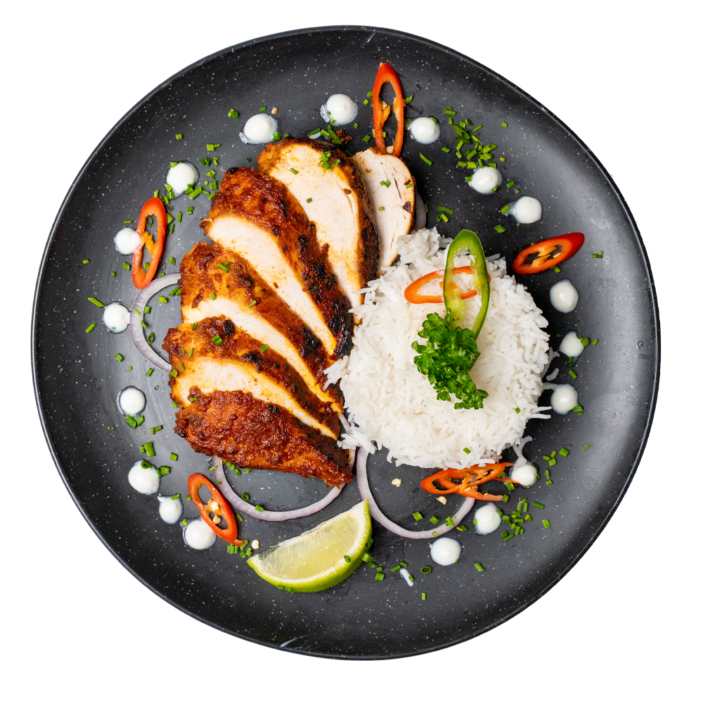 Chicken meal with fluffy white rice, colourful garnish, and sauce elegantly arranged on a plate for Corporate Meal Prep Lunches.