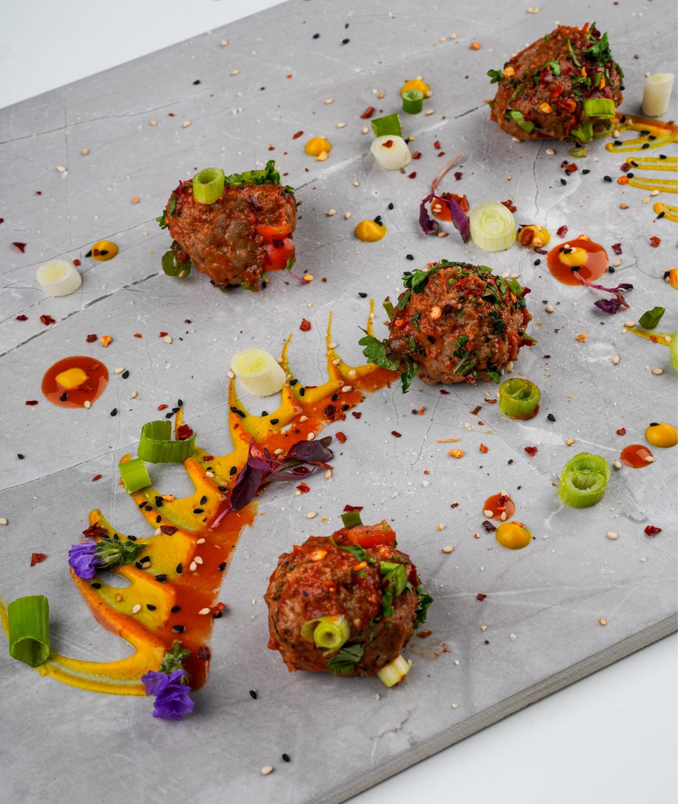 Chef-prepared corporate lunch on a slate plate with garnish and sauce, high-protein low-carb