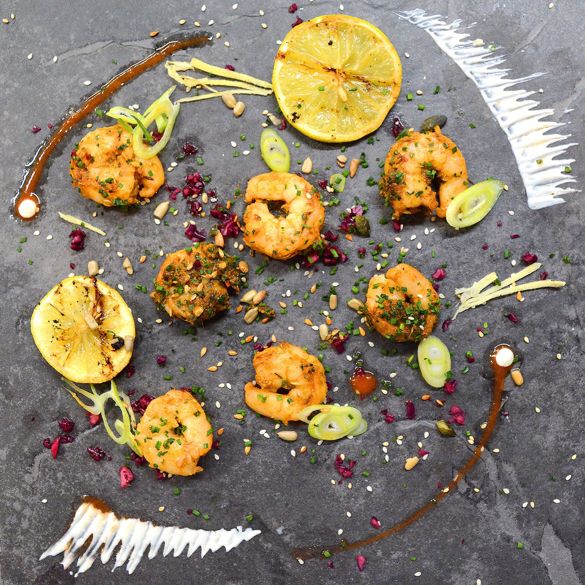 King Prawn premium meal with colourful garnish, and sauce elegantly arranged on a grey slate for Corporate Meal Prep Lunches in Nottingham